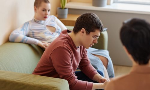 Young couple discussing problems with psychologist during session in office